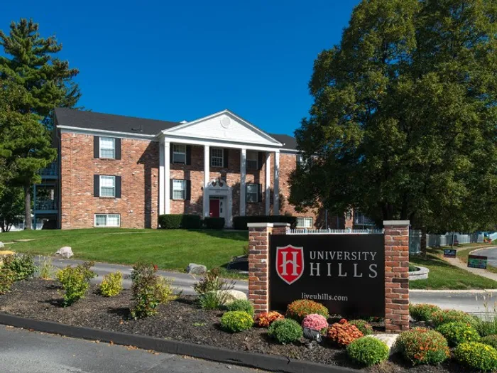 Exterior view of University Hills Apartments with signage and landscaped entrance near the University of Toledo