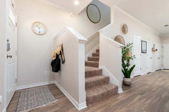Spacious entryway with carpeted staircase and modern decor at Seaglass Apartments in Corpus Christi