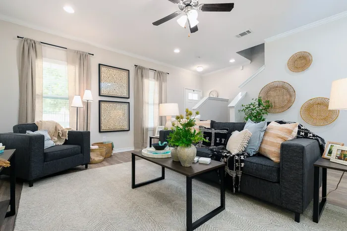 Stylish living room with ceiling fan and curtains at Seaglass Apartments in Corpus Christi