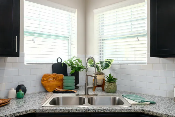 Modern kitchen with pull-down faucet and granite countertops at Seaglass Apartments in Corpus Christi