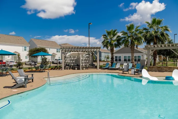 Resort-style pool with shaded seating and lounge chairs at Seaglass Apartments in Corpus Christi