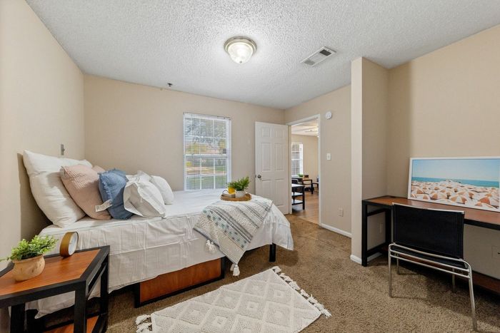 Large bedroom with a desk and study space at Theater Street Apartments in Lafayette, LA