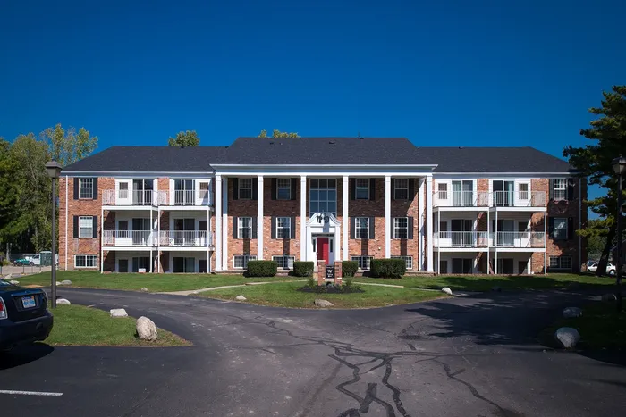 Front view of University Hills Apartments with classic brick architecture and balconies near the University of Toledo