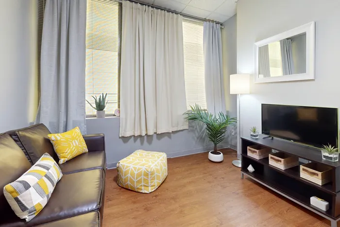 A4 Living room with wood-style flooring and curtains in University Plaza student apartments near NIU