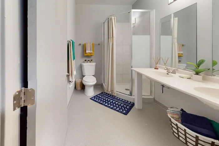Spacious bathroom featuring a double vanity and standing shower in University Plaza off-campus apartments near NIU