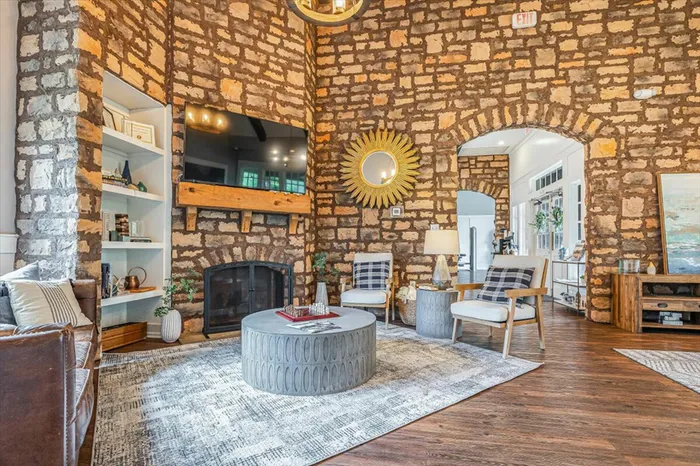 Warm and inviting clubhouse at The Cottages of Hattiesburg, featuring a stone fireplace, comfortable seating, and rustic decor, perfect for residents to relax and socialize.