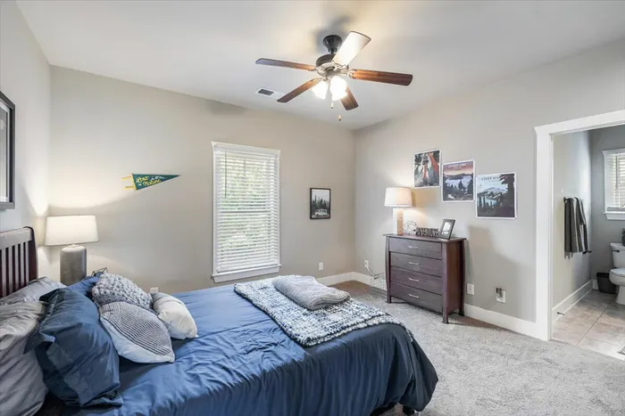 Large student bedroom at The Cottages of Hattiesburg featuring a cozy bed, modern decor, and private bathroom, offering a comfortable and relaxing living space.