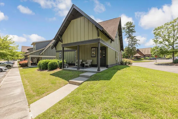 Charming cottage-style townhomes at The Cottages of Hattiesburg featuring spacious front porches and green lawns, offering a peaceful and comfortable student living environment.