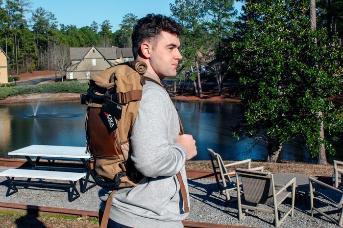Student enjoying a peaceful lakeside view at The Cottages of Hattiesburg, offering a serene environment with comfortable seating by the water.