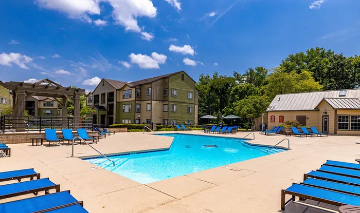 Sparkling pool with lounge chairs at Hawks Landing Apartments