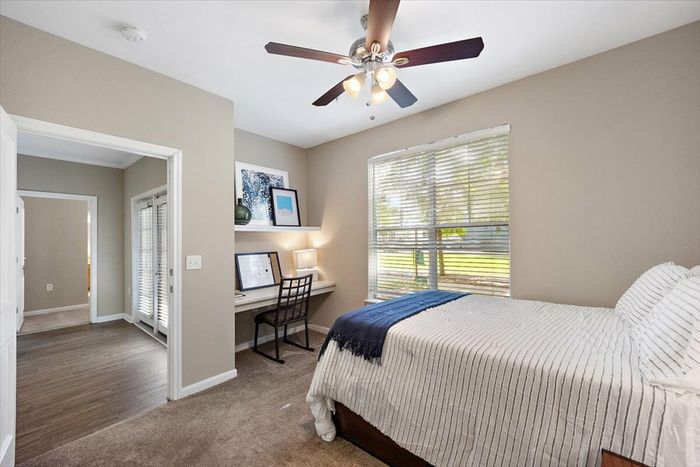 Cozy bedroom with a built-in desk and large window at Eagle Flatts Apartments in Hattiesburg, MS.