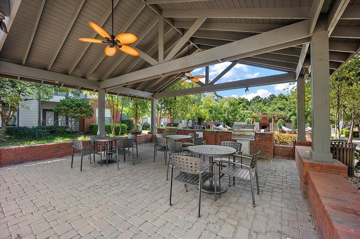 Outdoor grilling and dining area with shaded seating at Eagle Flatts Apartments in Hattiesburg, MS.