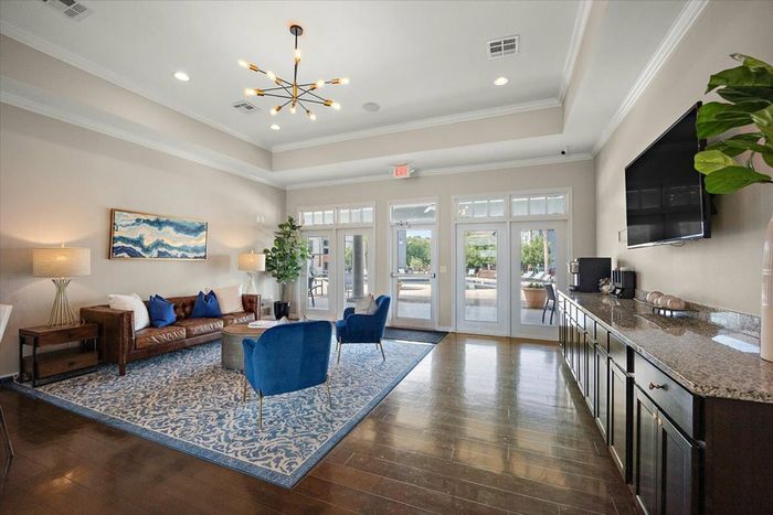 Modern and inviting clubhouse lounge at Eagle Flatts Apartments in Hattiesburg, MS with comfortable seating and a coffee station.