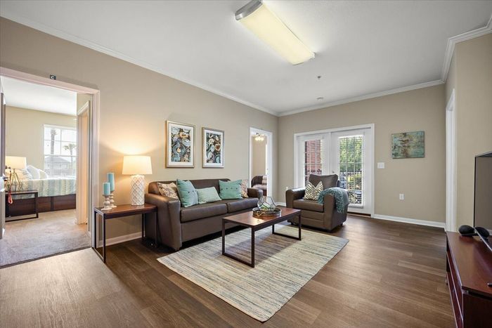 Spacious living room and bedroom area at Eagle Flatts Apartments in Hattiesburg, MS with modern furnishings and natural light.