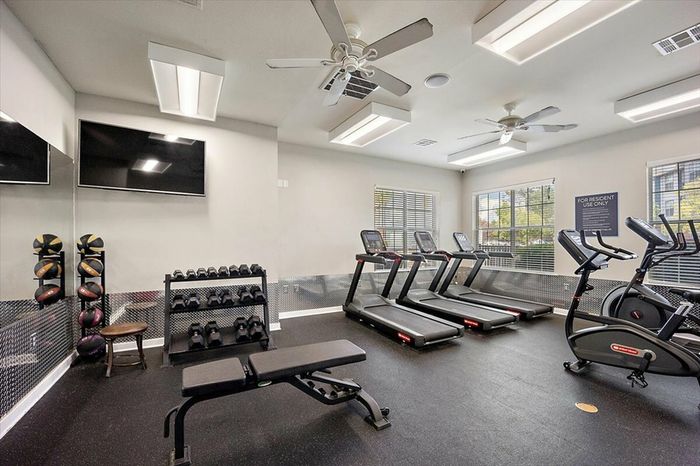 Fitness center with cardio machines, free weights, and strength training equipment at Eagle Flatts Apartments in Hattiesburg, MS.