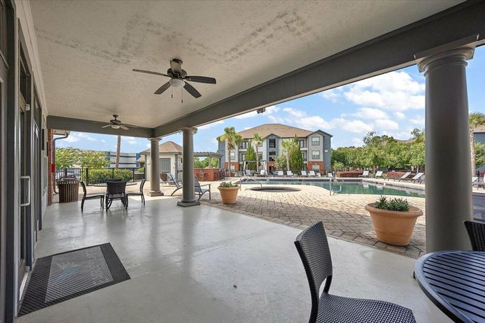 Covered poolside seating area with ceiling fans at Eagle Flatts Apartments in Hattiesburg, MS.