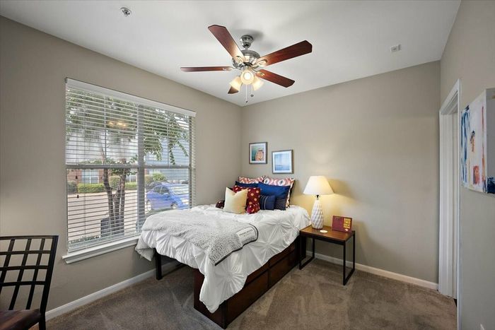 Cozy bedroom with ceiling fan and large window at Eagle Flatts Apartments in Hattiesburg, MS.