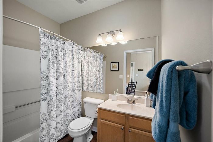 Spacious bathroom with vanity, shower/tub combo, and modern lighting at Eagle Flatts Apartments in Hattiesburg, MS.