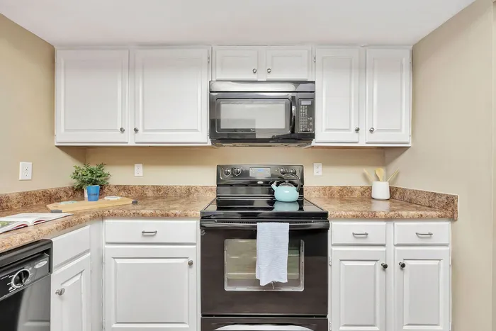 Kitchen with black appliances and granite-style counters