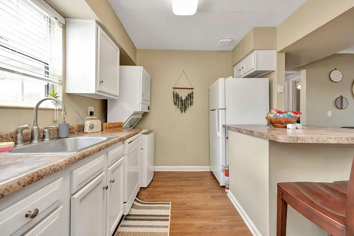 Large kitchen with ample counter space and stacked laundry machines at The Commons student apartments in Oxford, OH