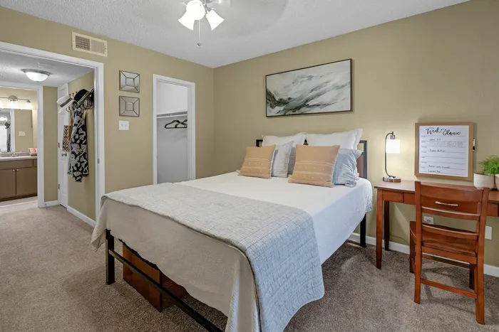 Spacious bedroom with carpet flooring and a walk-in closet at Raiders Walk apartments