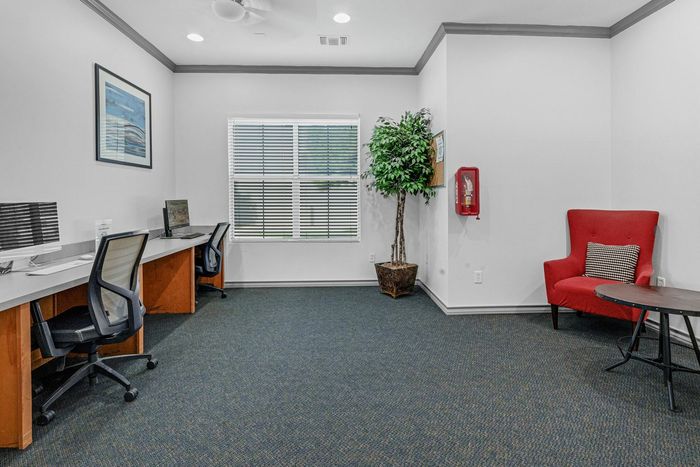 Business center with desks, chairs, and plenty of natural light