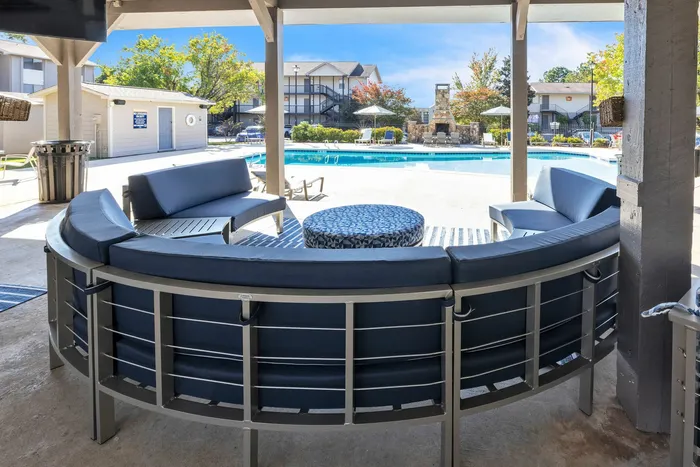 Poolside lounge area with shaded pavilion at Eagles West Apartments in Auburn, AL.