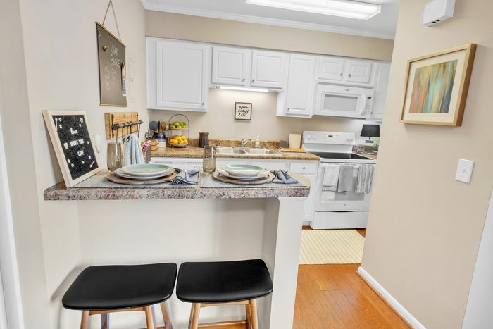 Modern kitchen with breakfast bar and full appliance package at Eagles West Apartments in Auburn, AL.