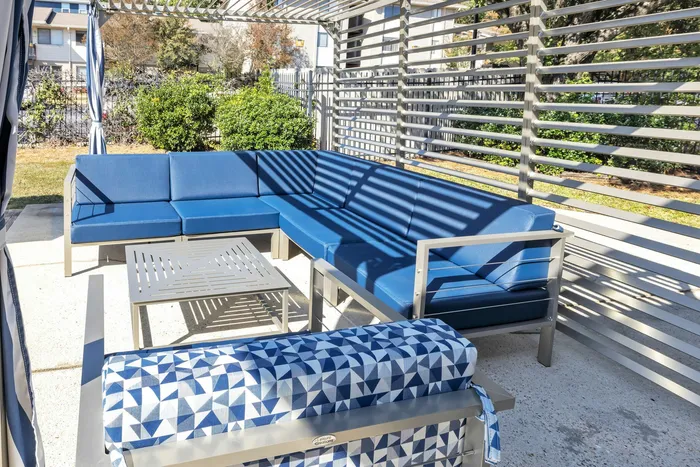 Poolside lounge area with shaded pavilion at Eagles West Apartments in Auburn, AL.