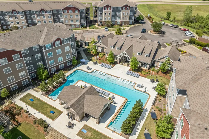 Aerial view of resort-style pool, hammock garden, grilling area, and outdoor games at The Flatts Starkville near MSU.