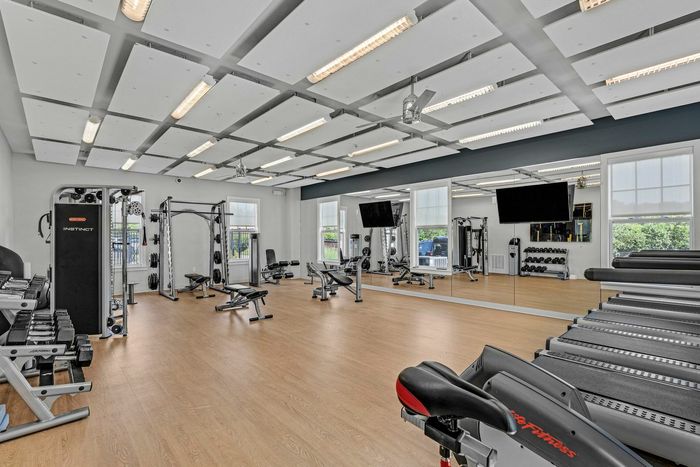 Fitness center with cardio equipment, TVs, free weights and bench press