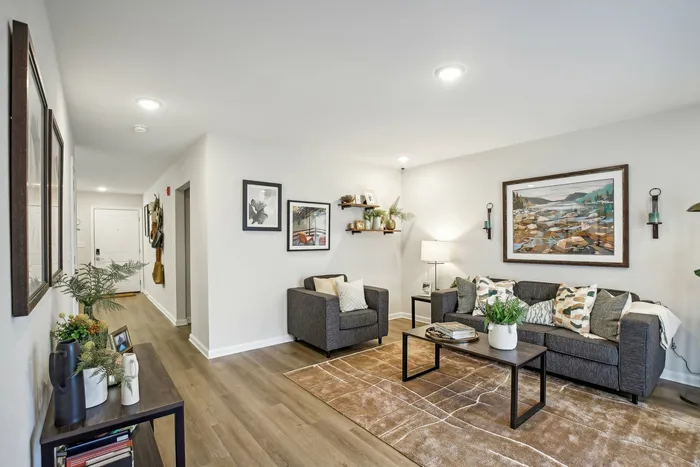Spacious living room with modern decor, wood-style flooring, and a cozy seating area at The Preserve Murfreesboro.