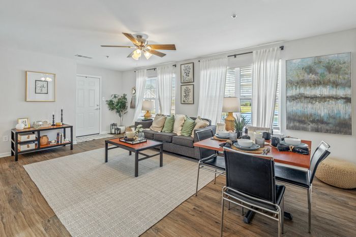 Living room with ceiling fan and track lighting fixture at Theater Street Apartments in Lafayette, LA