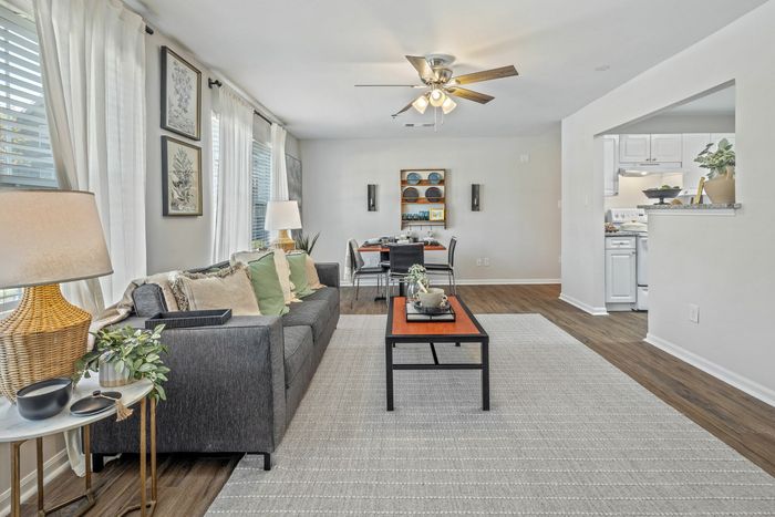 Modern living room with wood-style flooring and recessed lighting at Theater Street Apartments in Lafayette, LA