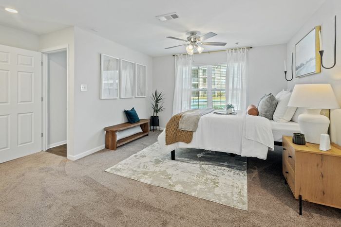 Spacious bedroom with carpets, ceiling fan, and nook at Theater Street Apartments in Lafayette, LA