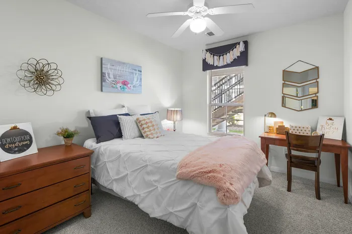 Charming bedroom with plush bedding, modern decor, and a cozy workspace, perfect for relaxation and inspiration.