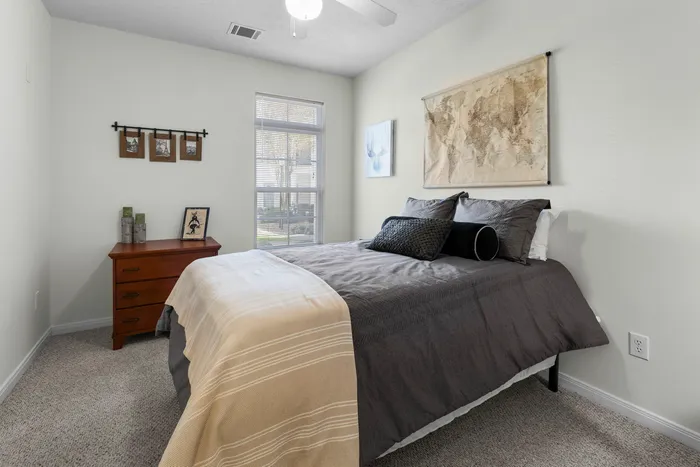 Bright and cozy bedroom with a large window, modern decor, and a comfortable bed, creating a serene and inviting atmosphere.