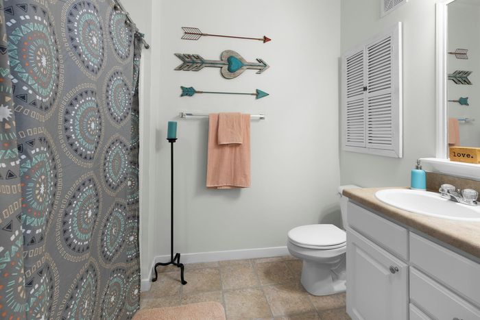 Chic bathroom with elegant geometric shower curtain, decorative wall arrows, and modern fixtures for a cozy atmosphere.