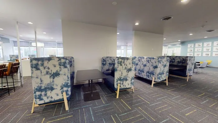 Modern seating area featuring stylish patterned booths and sleek tables, perfect for relaxation or casual meetings in a vibrant atmosphere.