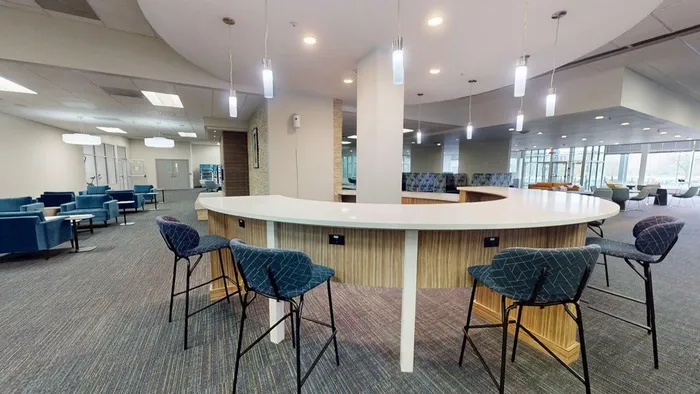 Elegant open-concept lounge area with a modern curved counter, stylish bar stools, and ample seating, perfect for relaxation and social gatherings.