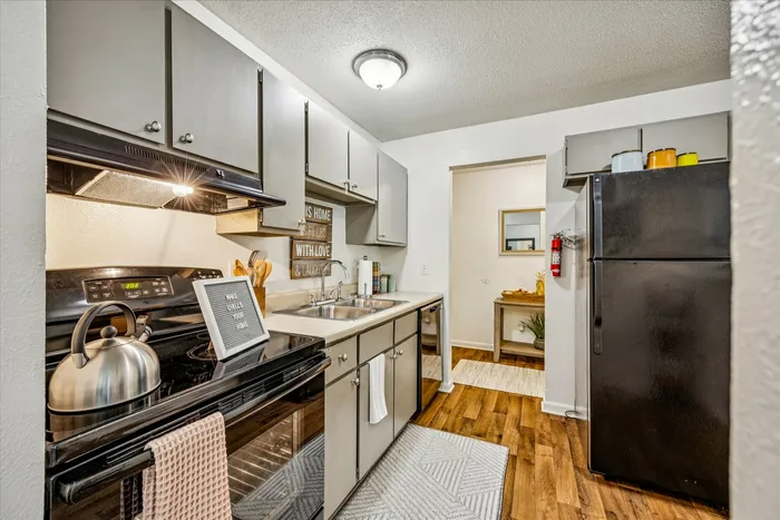 Inviting kitchen with modern appliances, sleek cabinets, and warm wooden flooring, exuding a cozy and functional atmosphere.