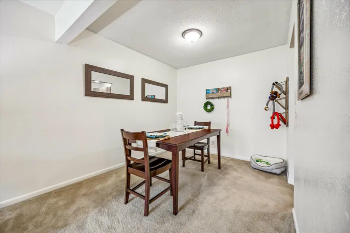 Cozy dining area with elegant wooden table and chairs, highlighted by modern decor and natural lighting, creating an inviting atmosphere.