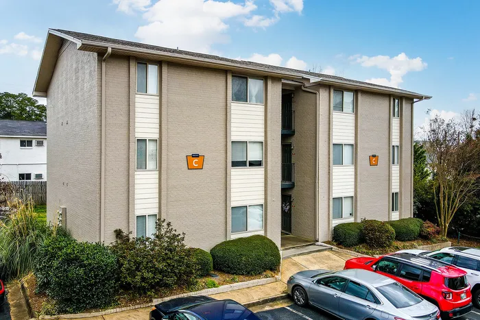 Charming apartment building with a modern exterior, neatly landscaped surroundings, and convenient parking.