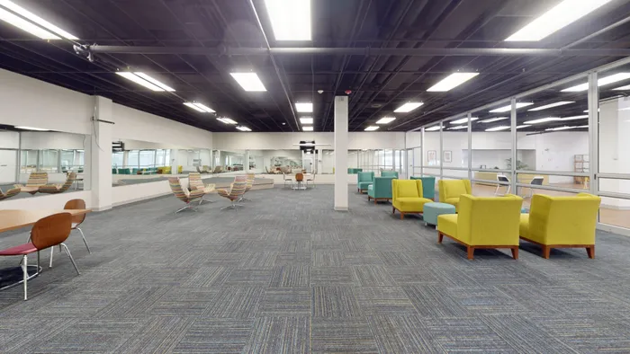 Modern open-concept lounge area with vibrant seating, stylish carpet, and ample natural light, perfect for social gatherings and relaxation.