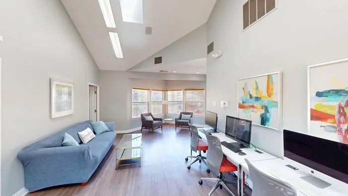 Bright and modern co-working space featuring skylights, contemporary art, and ample natural light.