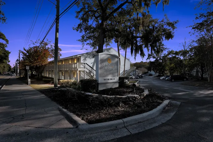 Inviting apartment complex illuminated at dusk, highlighting a charming facade with a welcoming atmosphere in a tranquil neighborhood.
