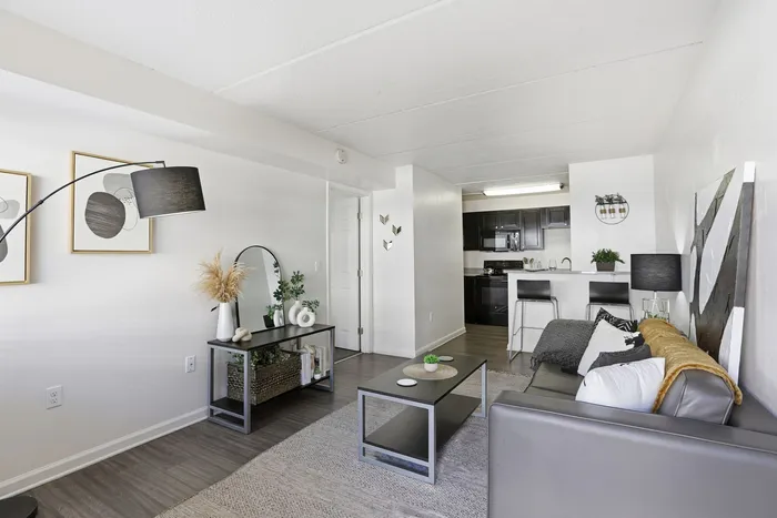 Modern living room with sleek decor, vibrant artwork, and a stylish open-plan kitchen, perfect for contemporary living.
