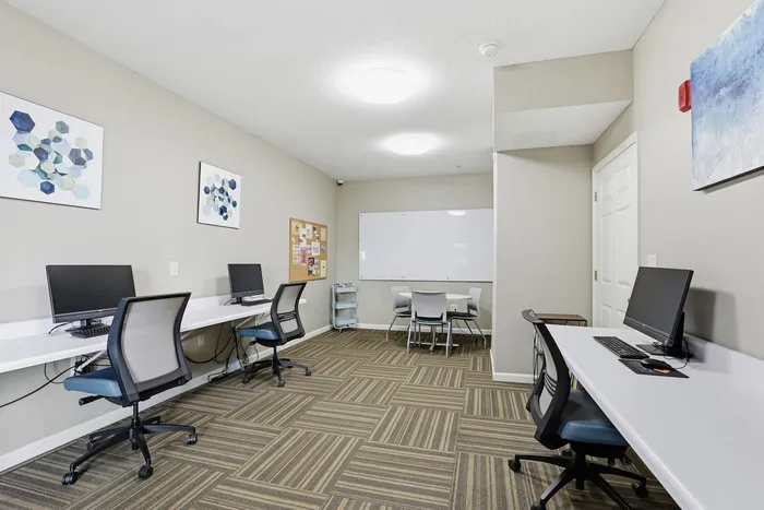 Modern work space with sleek desks, ergonomic chairs, and vibrant artwork, perfect for productivity and creativity.