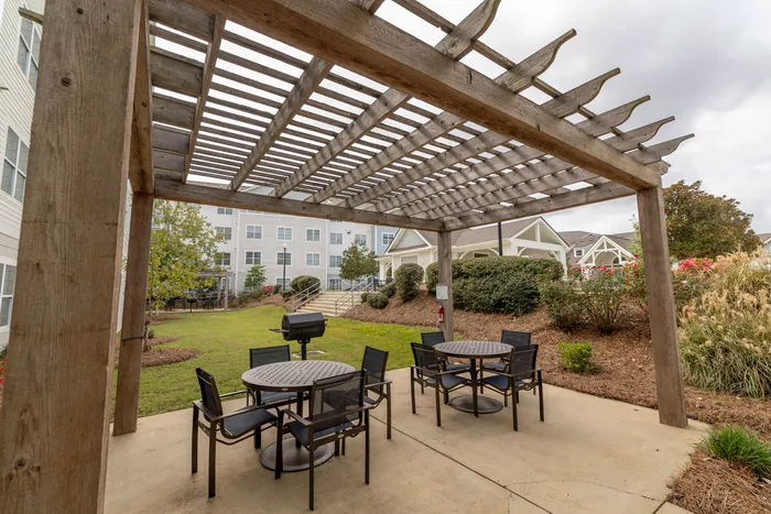 Charming outdoor space with stylish pergola, inviting seating, and lush greenery perfect for relaxation and entertainment.