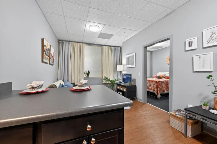 Contemporary apartment interior with open-plan design, featuring a cozy living area, stylish breakfast bar, and spacious bedroom adorned with modern decor.